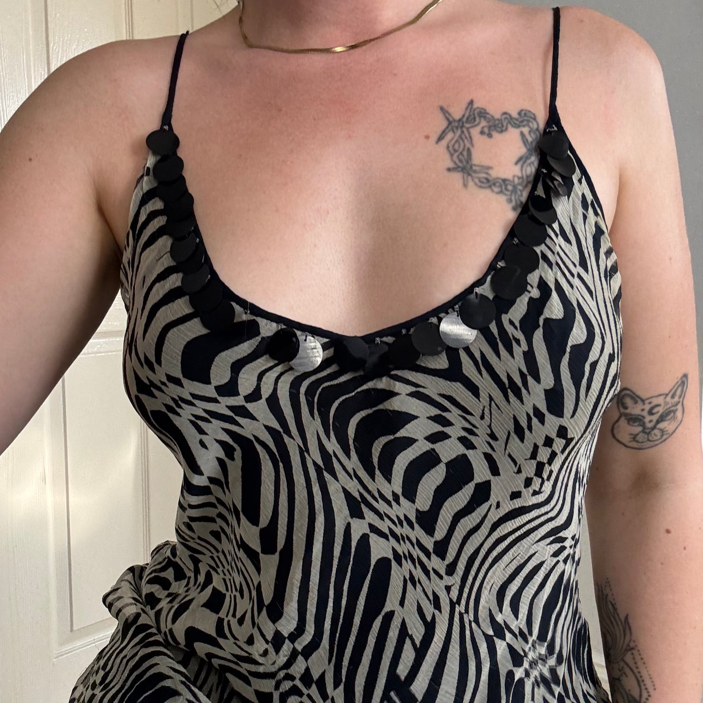 Person wearing a zebra print dress with black straps.