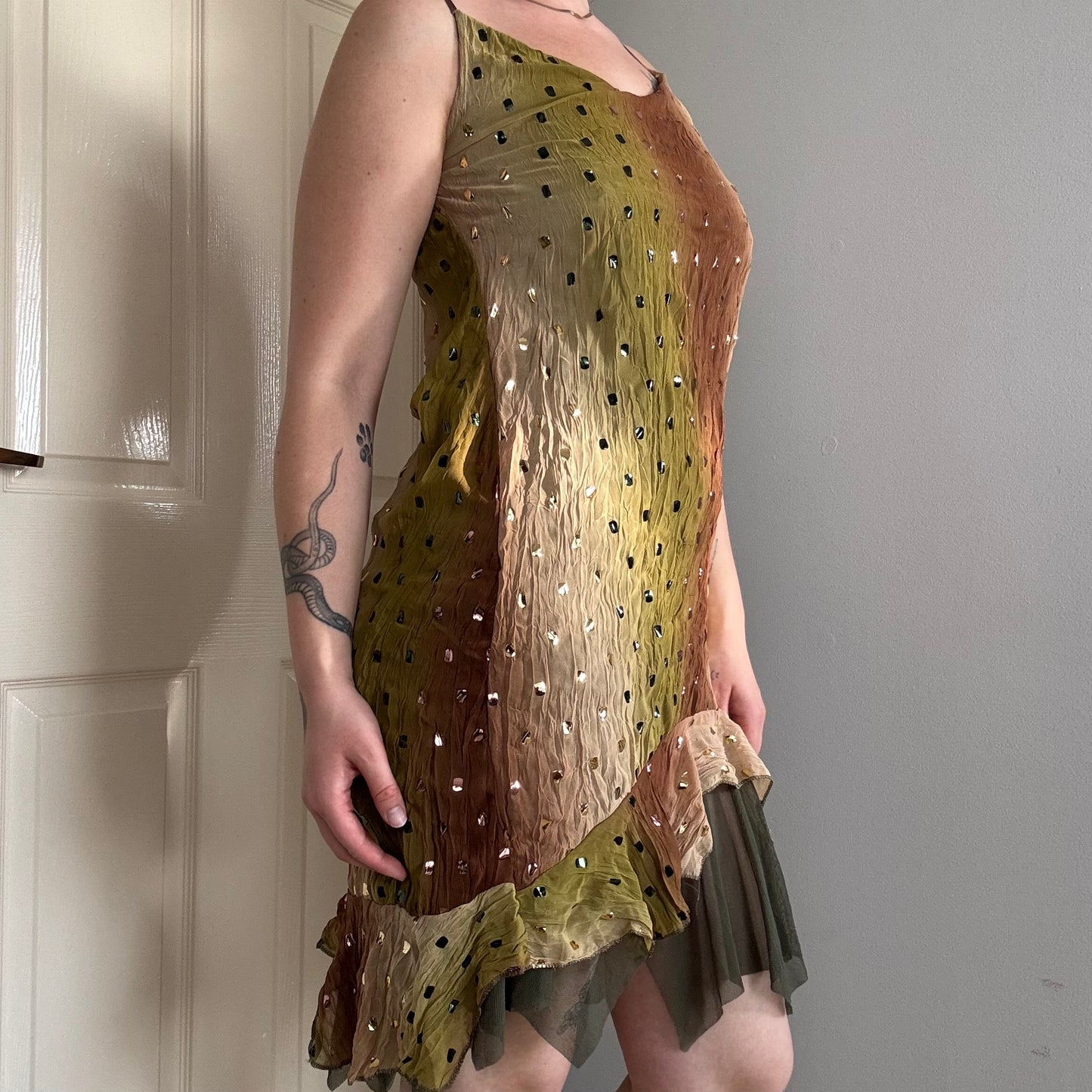 a person wearing a green flowy mesh fairy strappy mini dress.