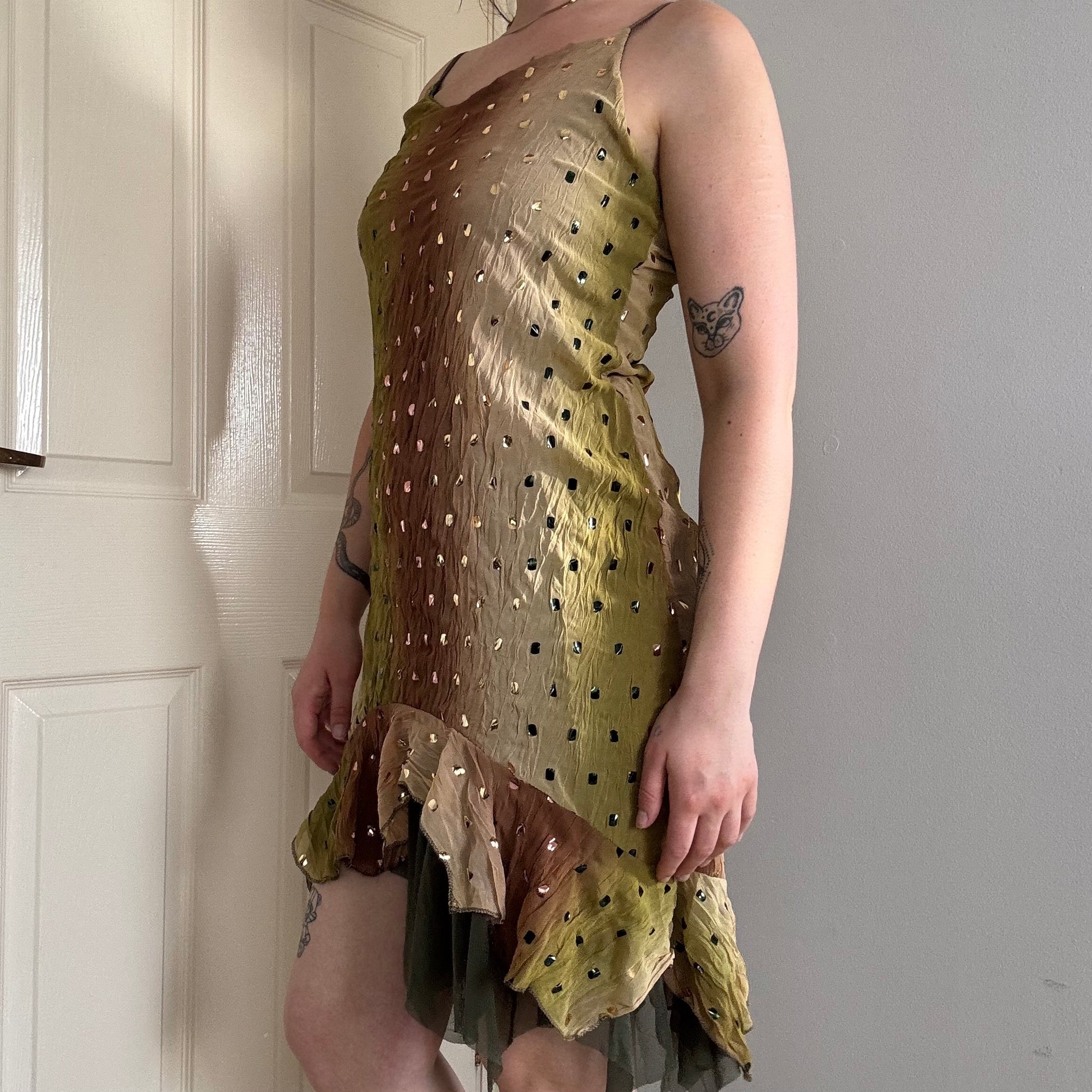 a person wearing a green flowy mesh fairy strappy mini dress.