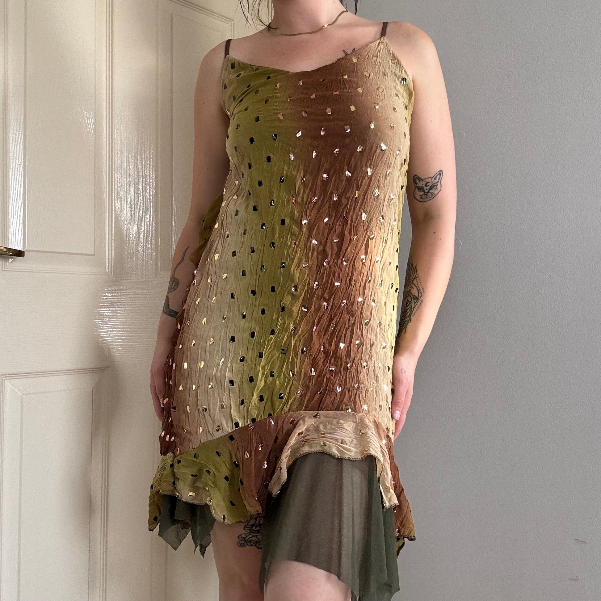 a person wearing a green flowy mesh fairy strappy mini dress.