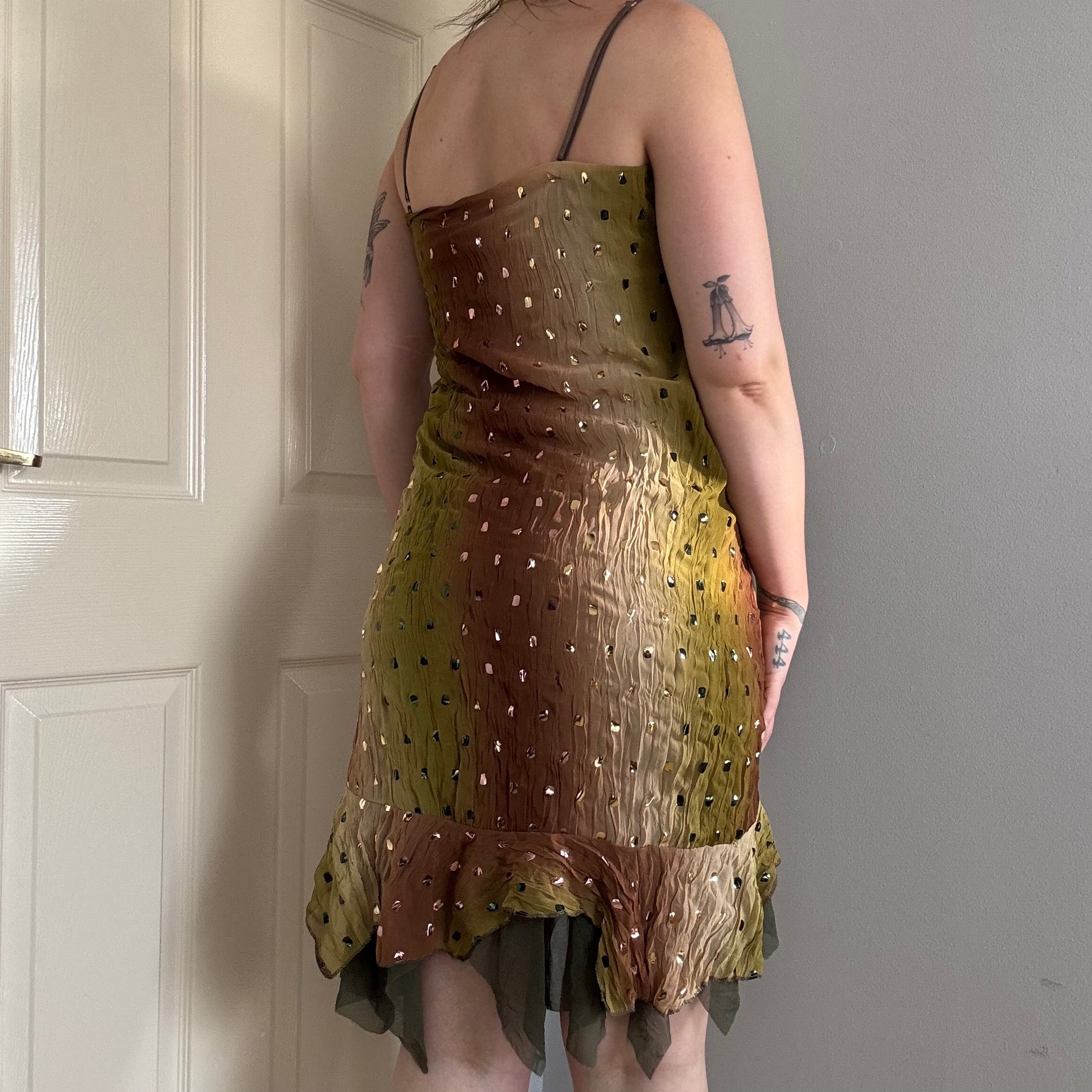 a person wearing a green flowy mesh fairy strappy mini dress.