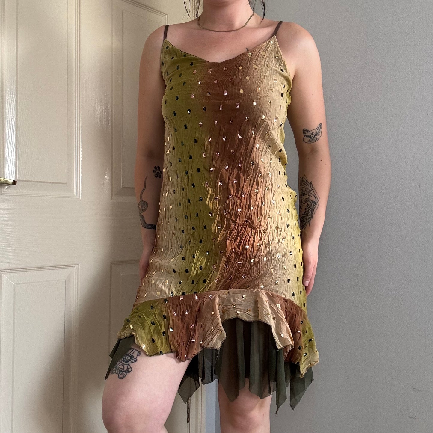 a person wearing a green flowy mesh fairy strappy mini dress.