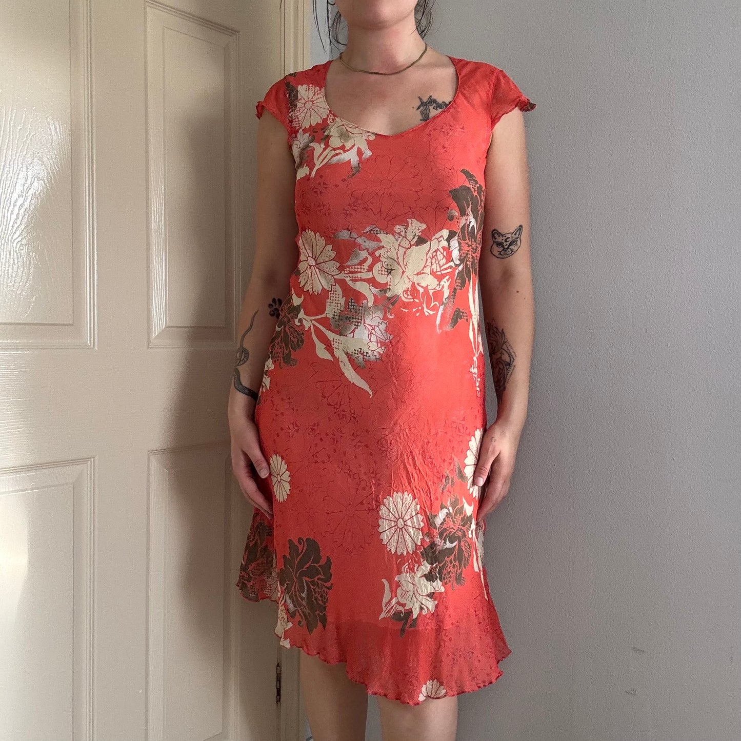Person wearing a vintage red floral summer dress .
