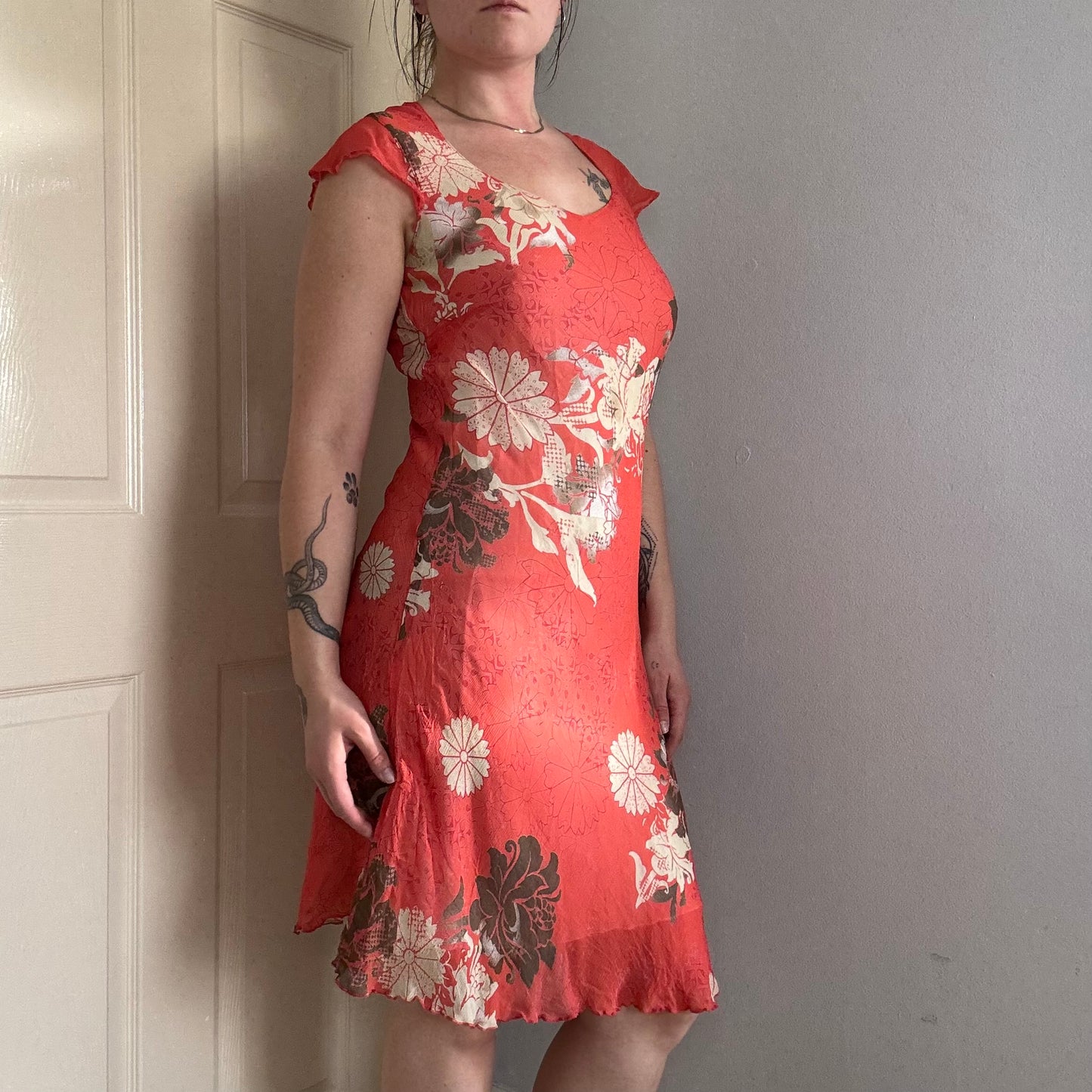 Person wearing a vintage red floral summer dress .