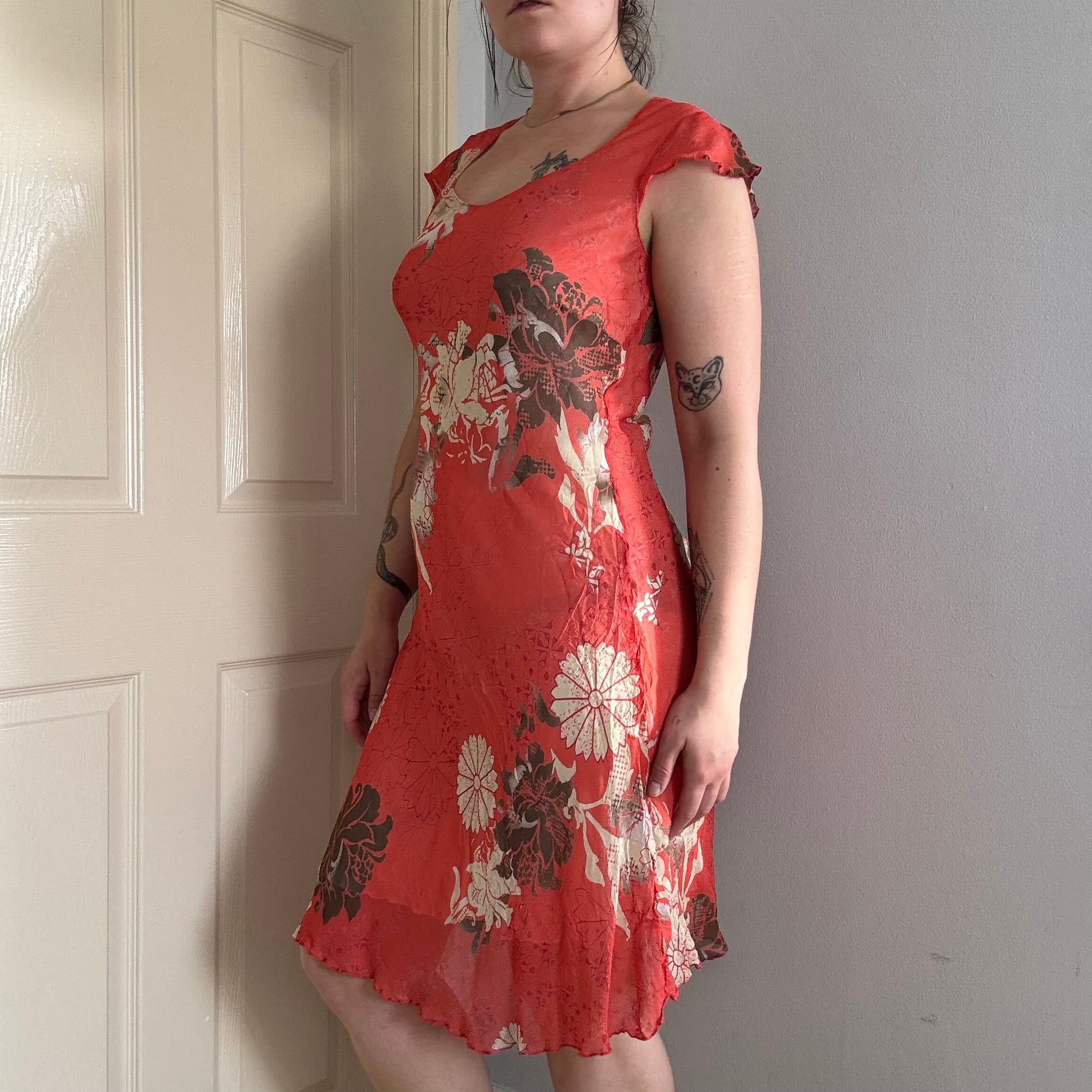 Person wearing a vintage red floral summer dress .