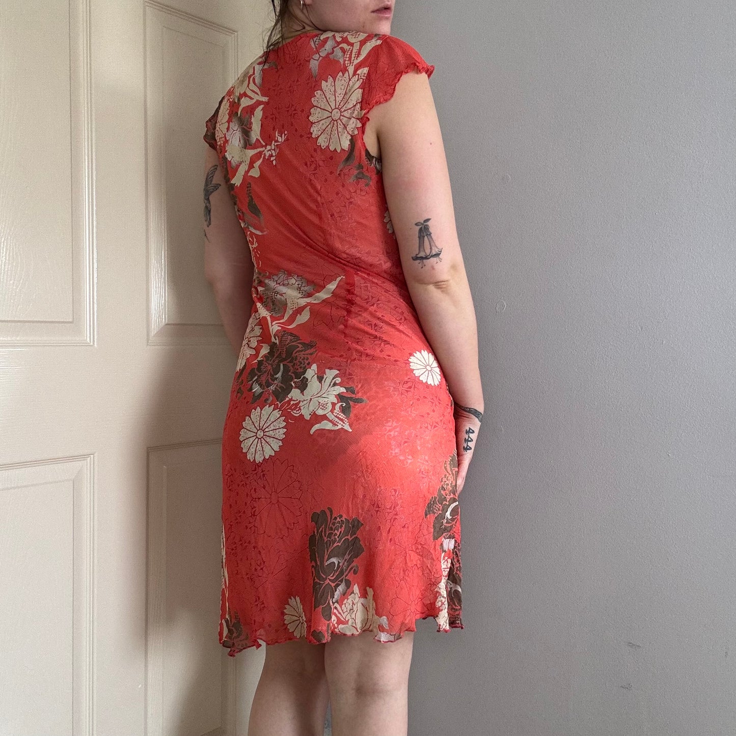Person wearing a vintage red floral summer dress .