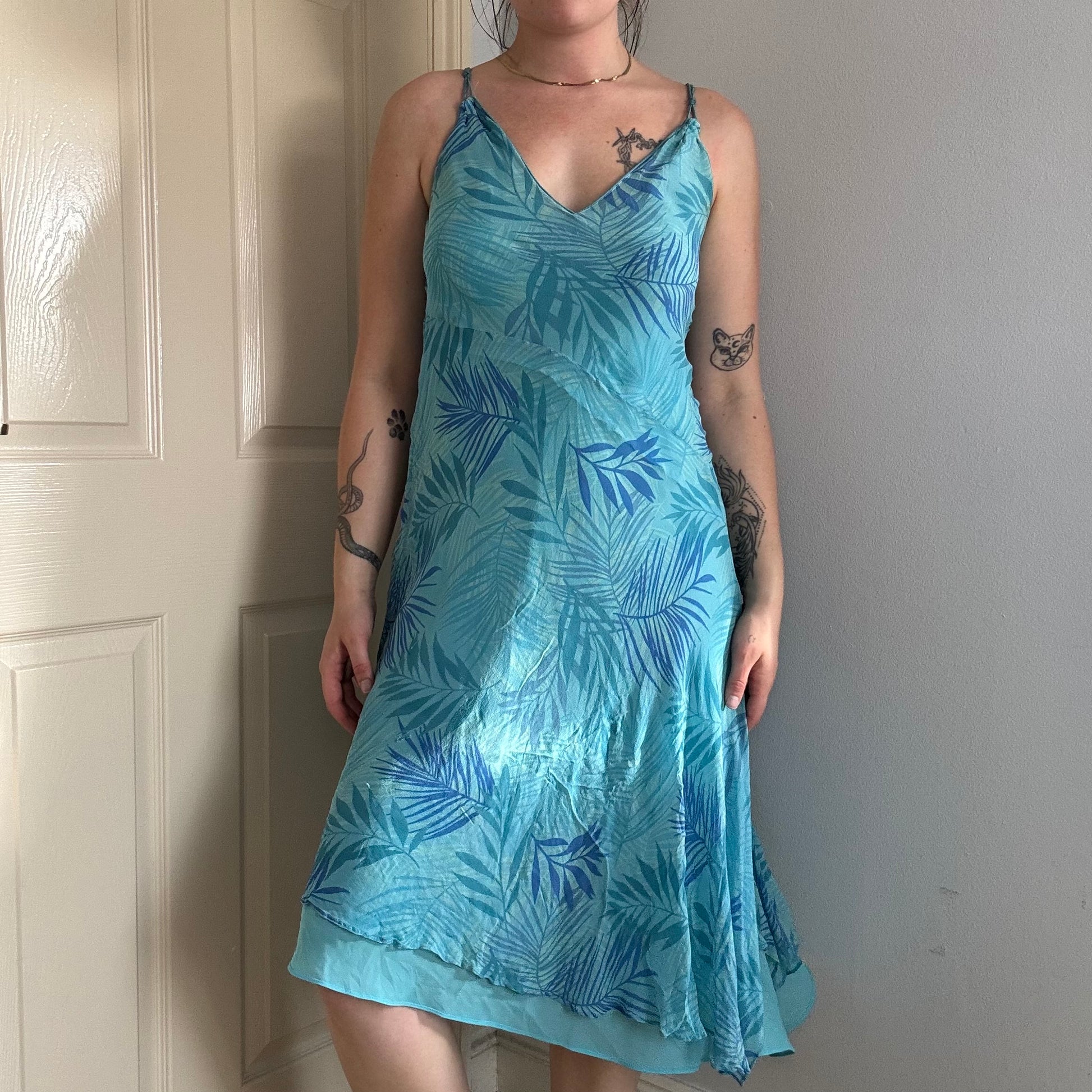 Person wearing a blue silk floral dress.