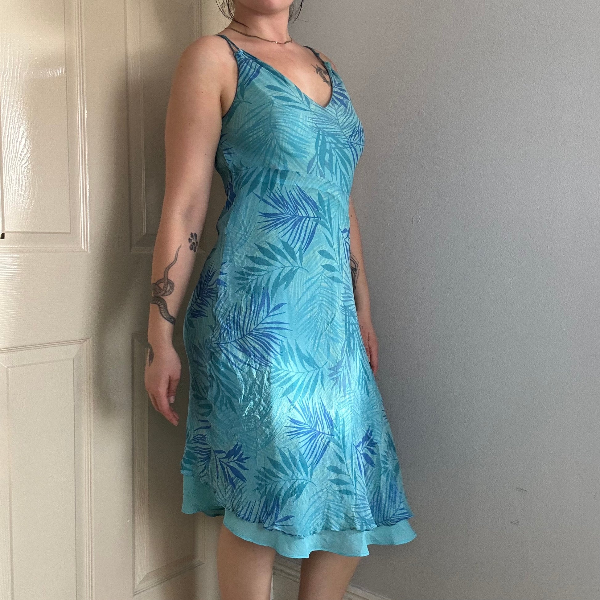 Person wearing a blue silk floral dress.