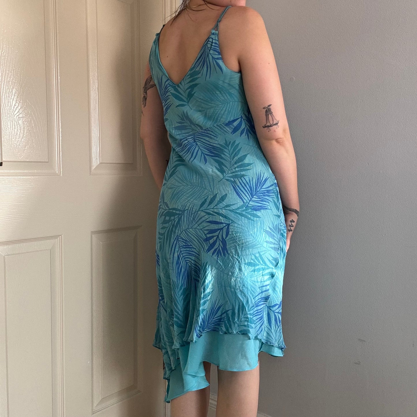 Person wearing a blue silk floral dress.