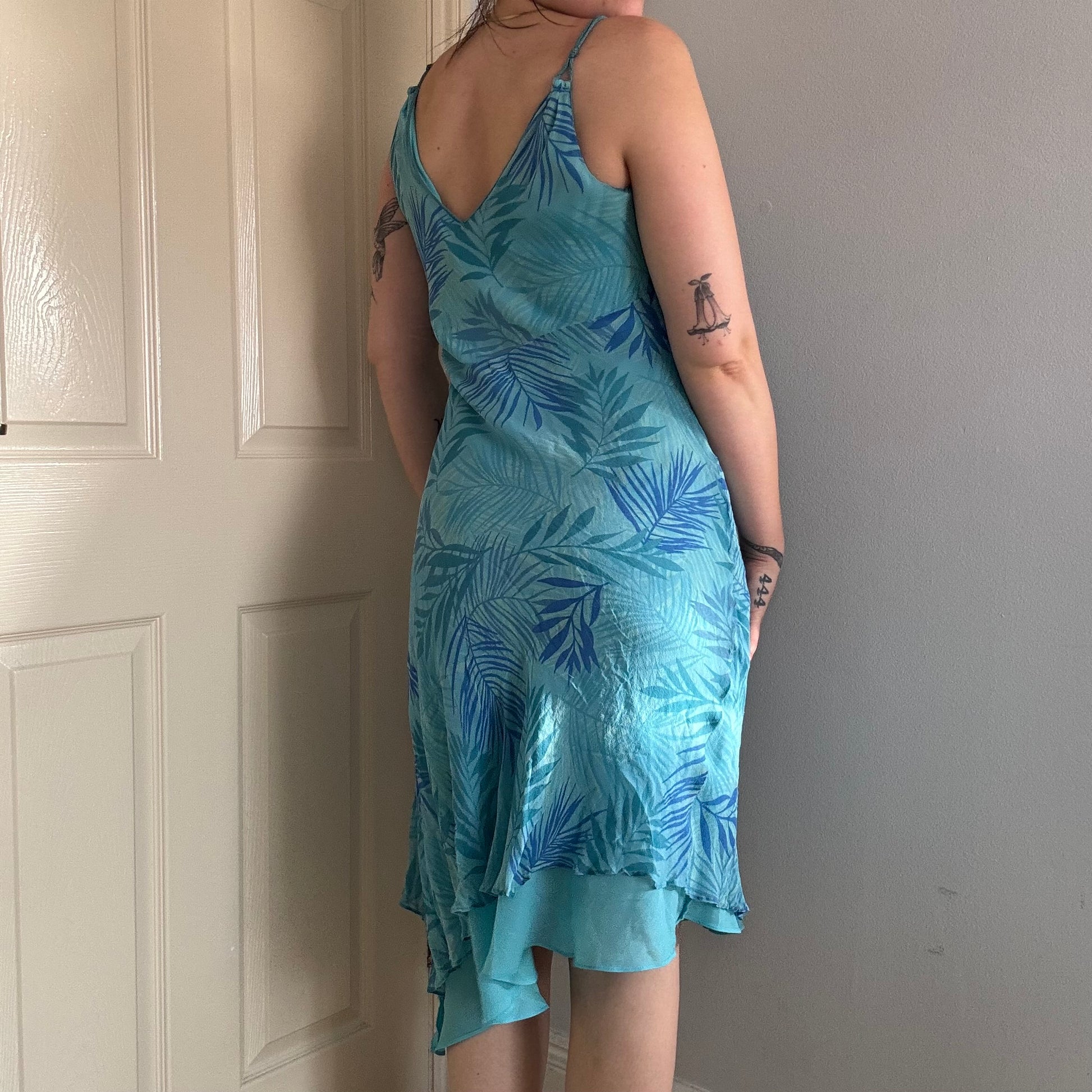Person wearing a blue silk floral dress.