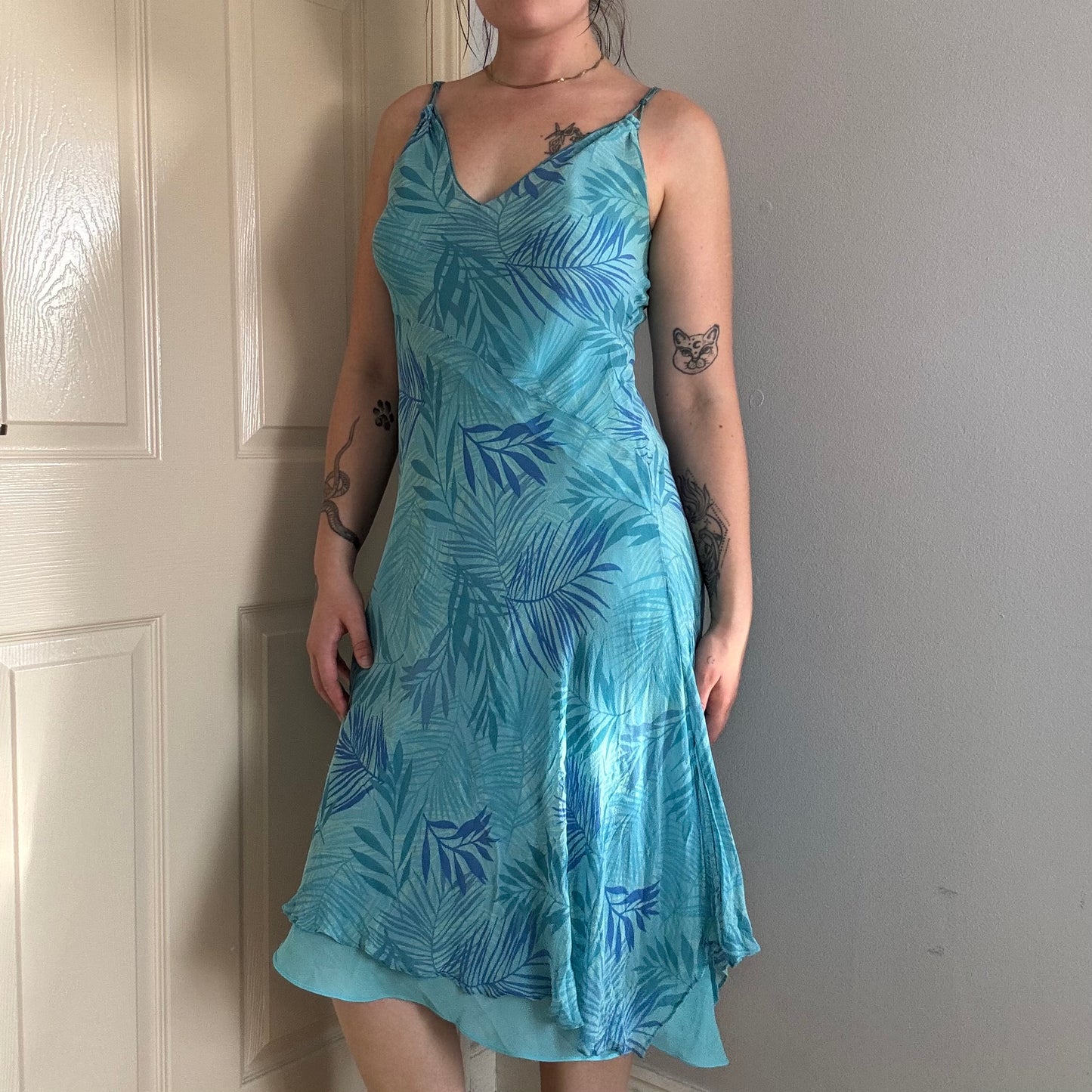 Person wearing a blue silk floral dress.