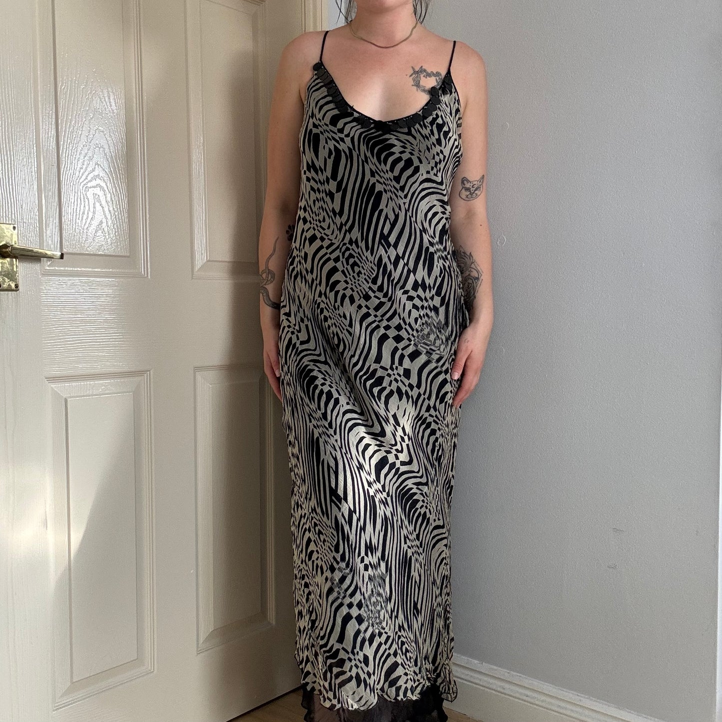 Person wearing a mesh zebra print maxi dress.