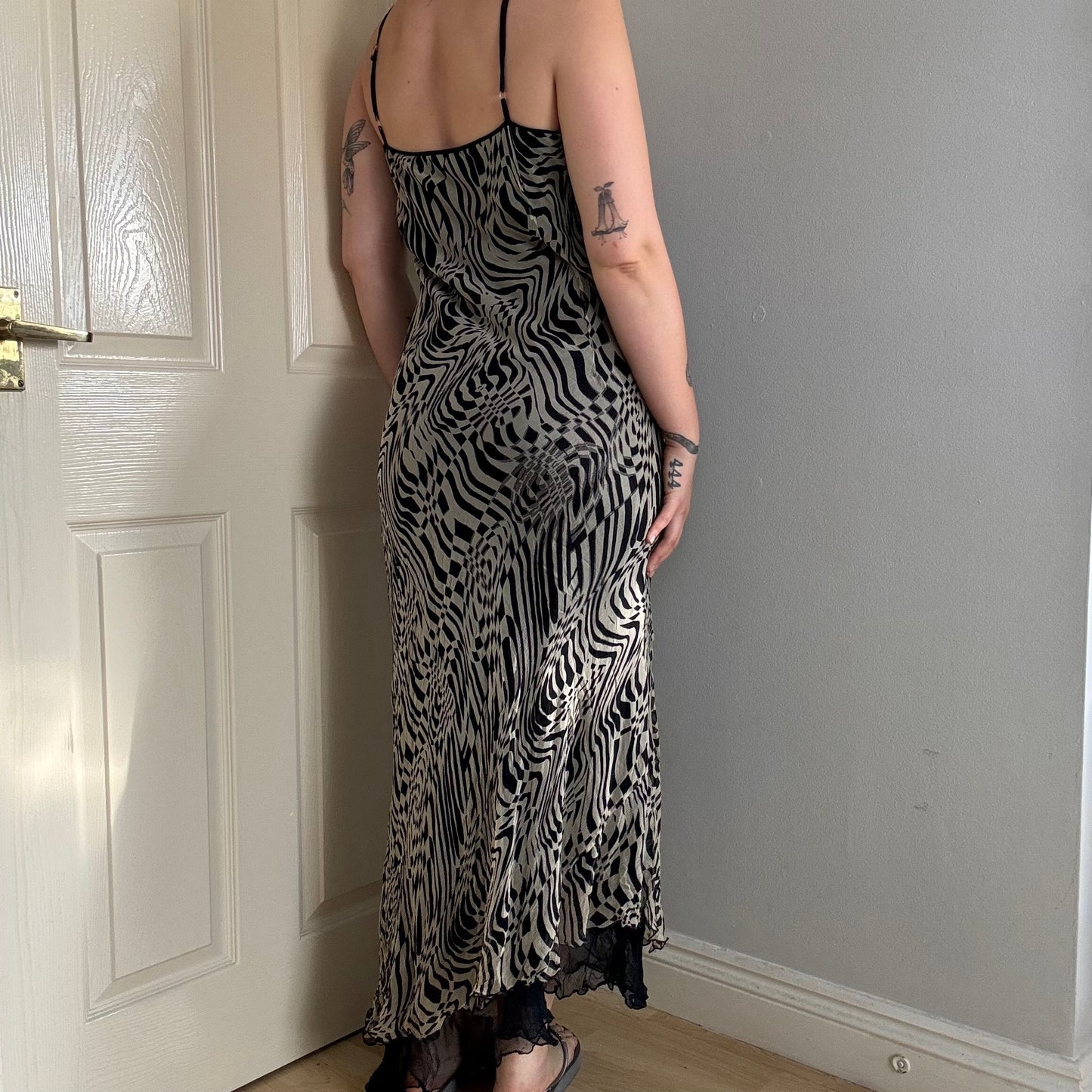 Person wearing a mesh zebra print maxi dress.