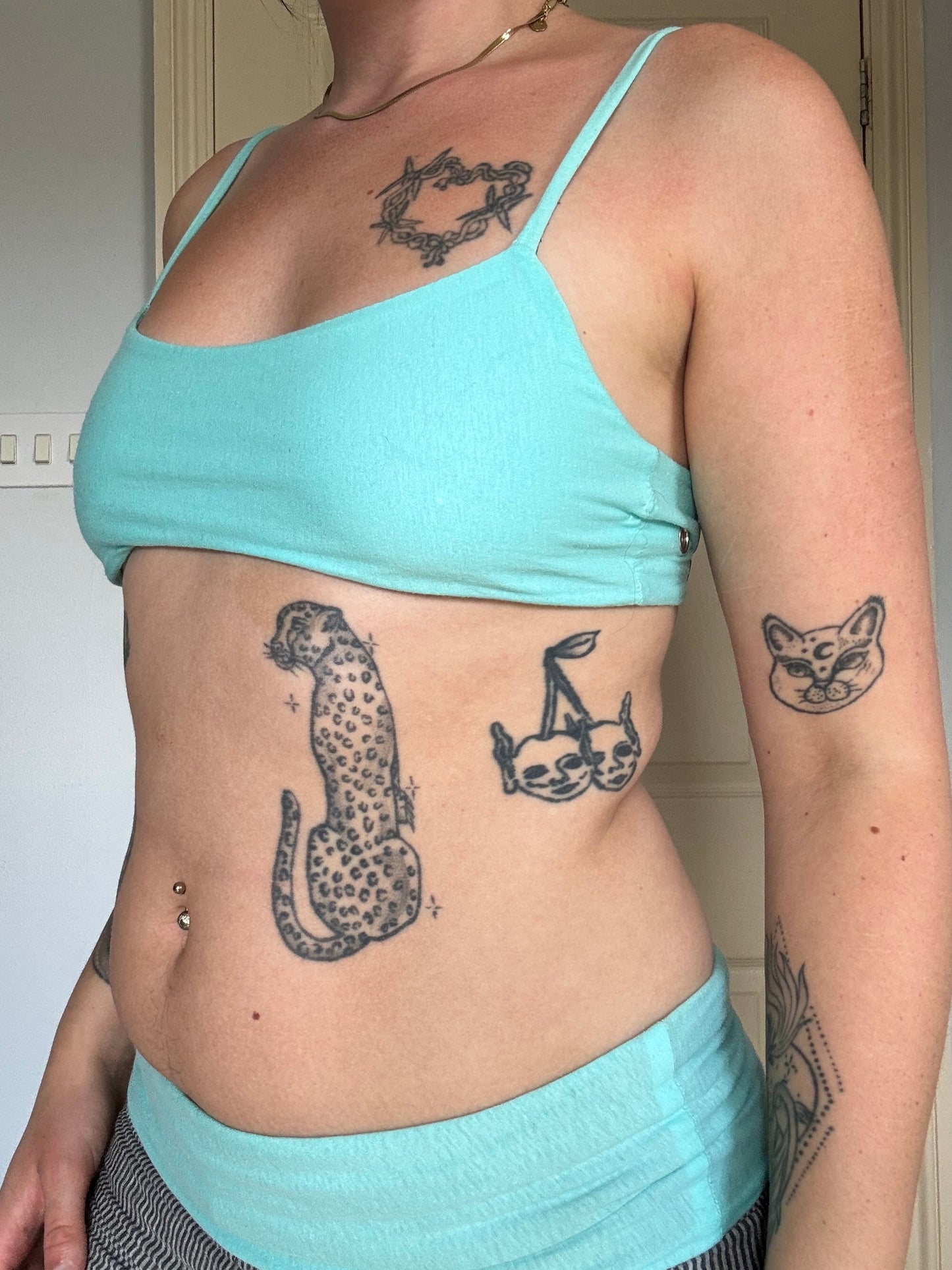 person wearing a turquoise cotton eyelet bralet with hanging brand tag.