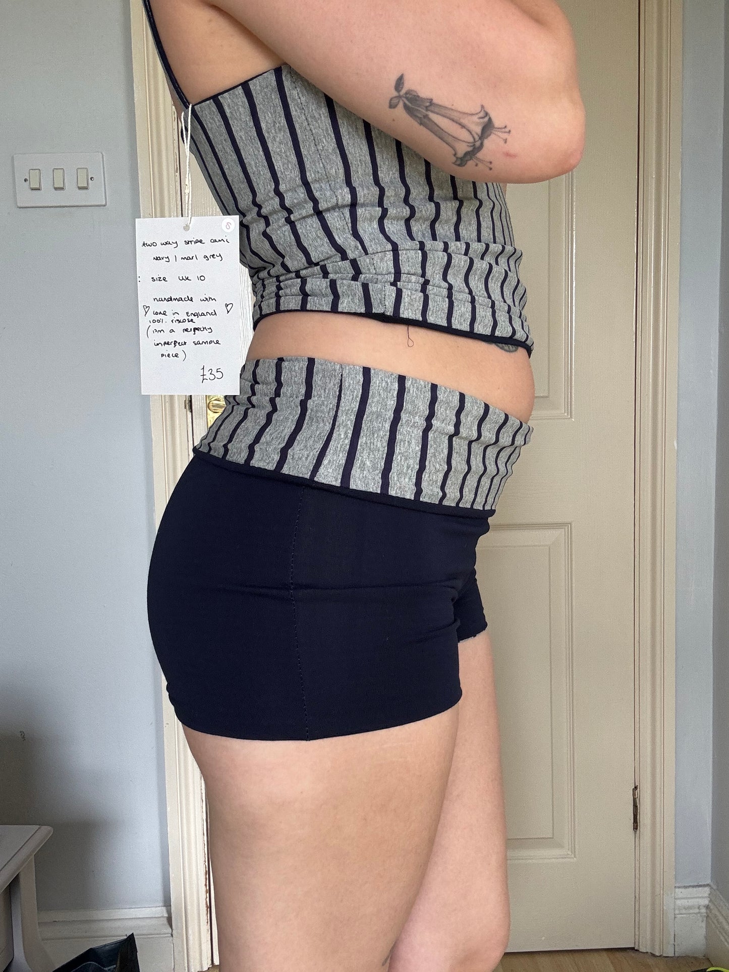 Person wearing navy blue and grey stripe reversible shorts with wide waistband.