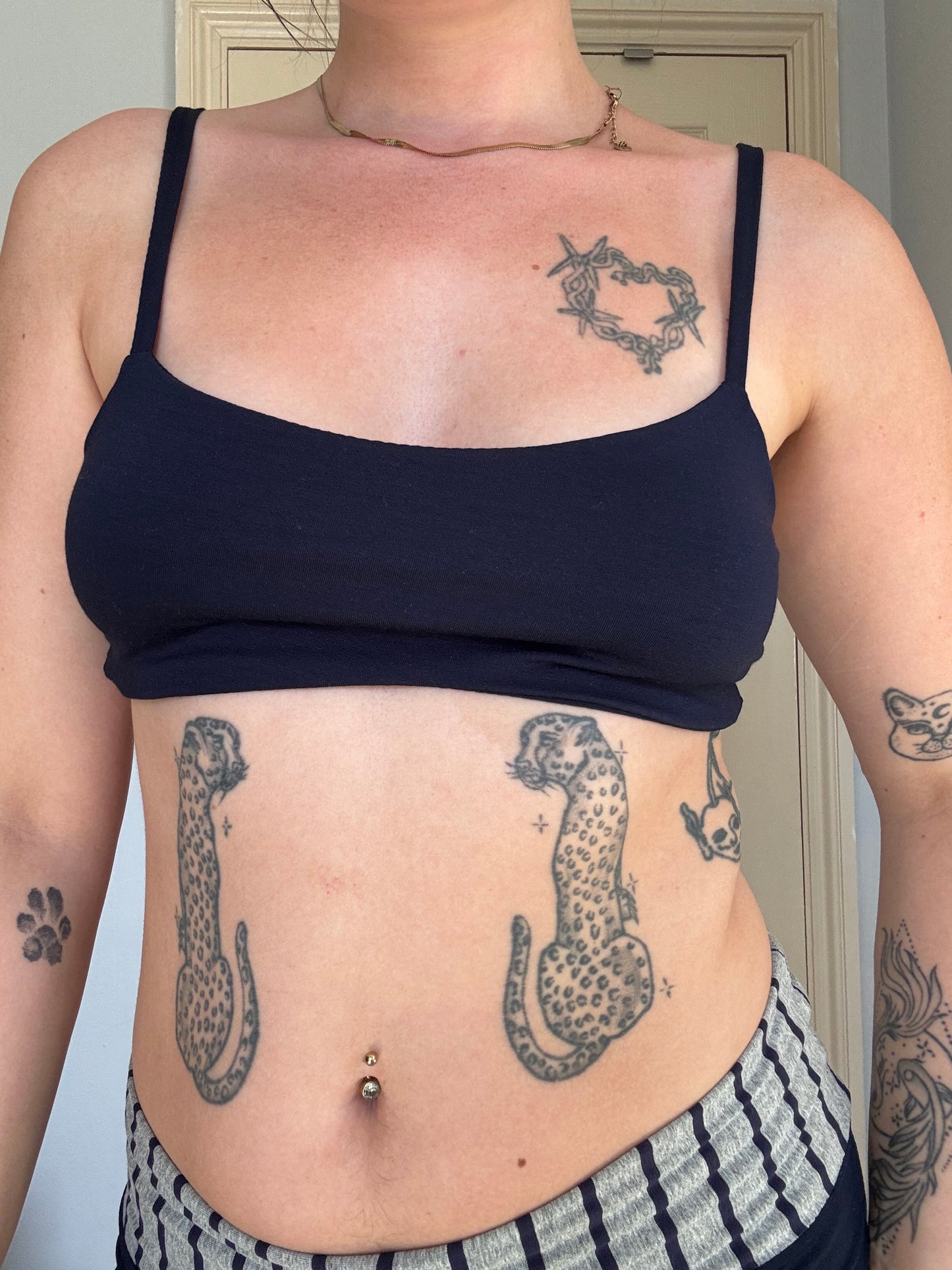 person wearing a navy blue stretchy eyelet bralet with hanging brand tag.