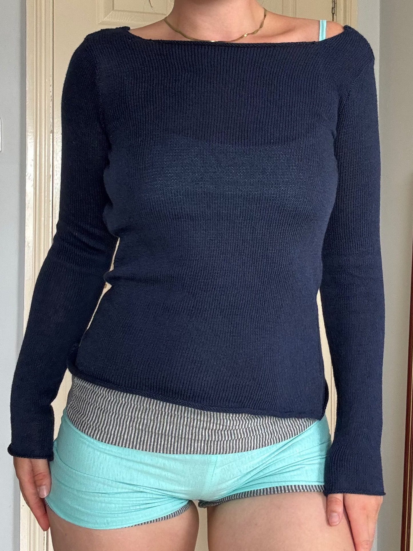 Person wearing a backless navy blue long sleeve cotton knit top over  turquoise eyelet bralet.