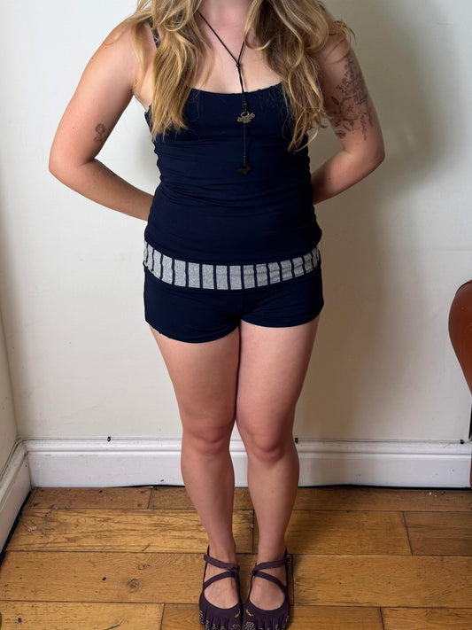 Person wearing a navy blue and grey stripe reversible tank top.