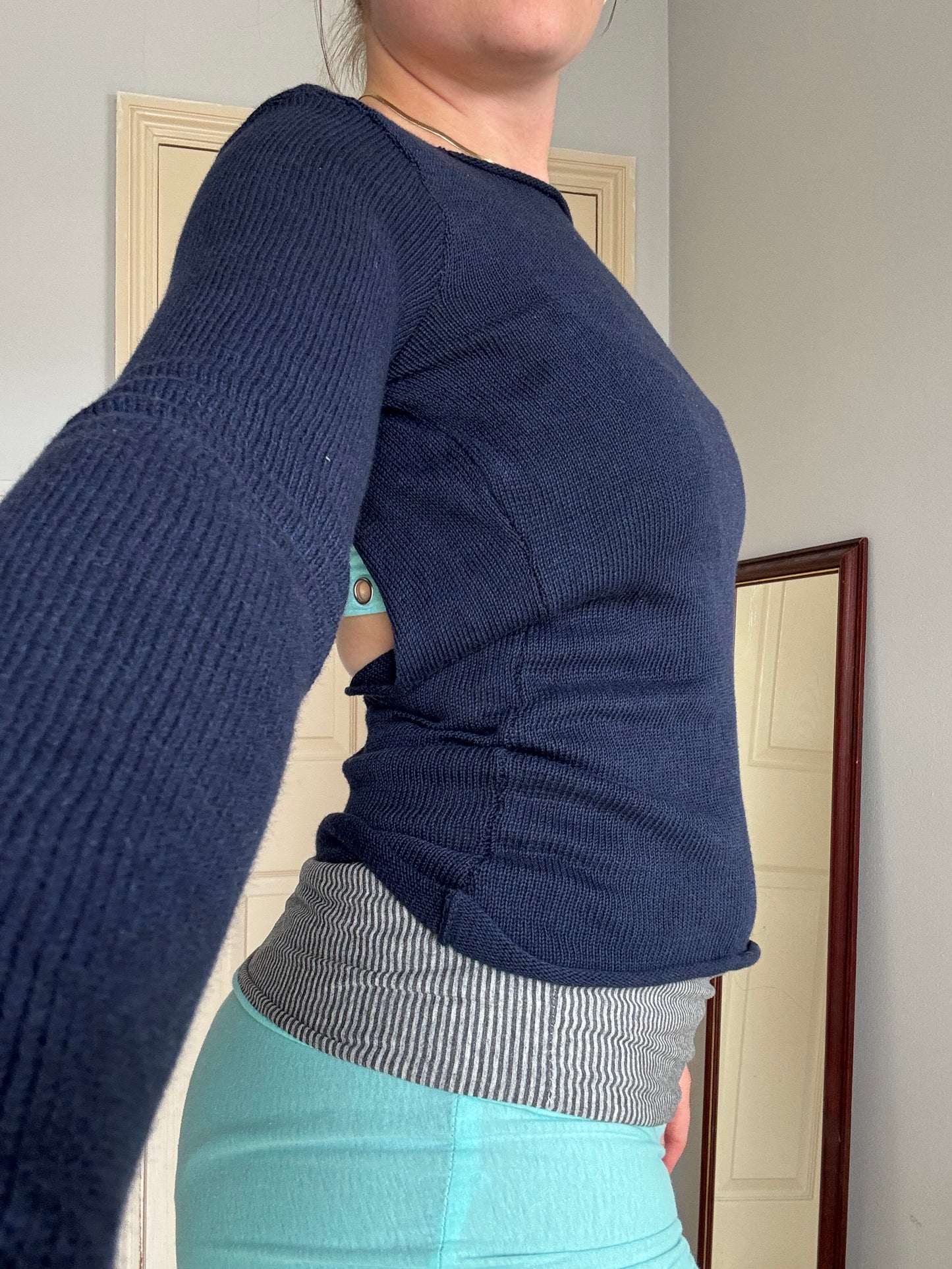 Person wearing a backless navy blue long sleeve cotton knit top over  turquoise eyelet bralet.